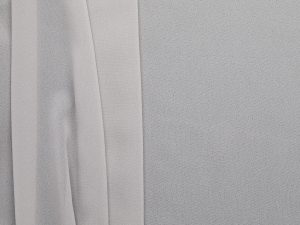 Grey poly chiffon fabric, flat lay showing soft drape and sheer quality