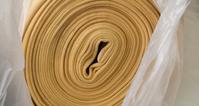 Roll of mustard surplus fabric on display — high-quality textile available for reuse through Circular Sourcing